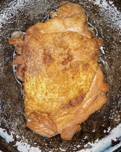 "Crispy chicken thigh seared skin-side down in a pan until golden and bubbling."