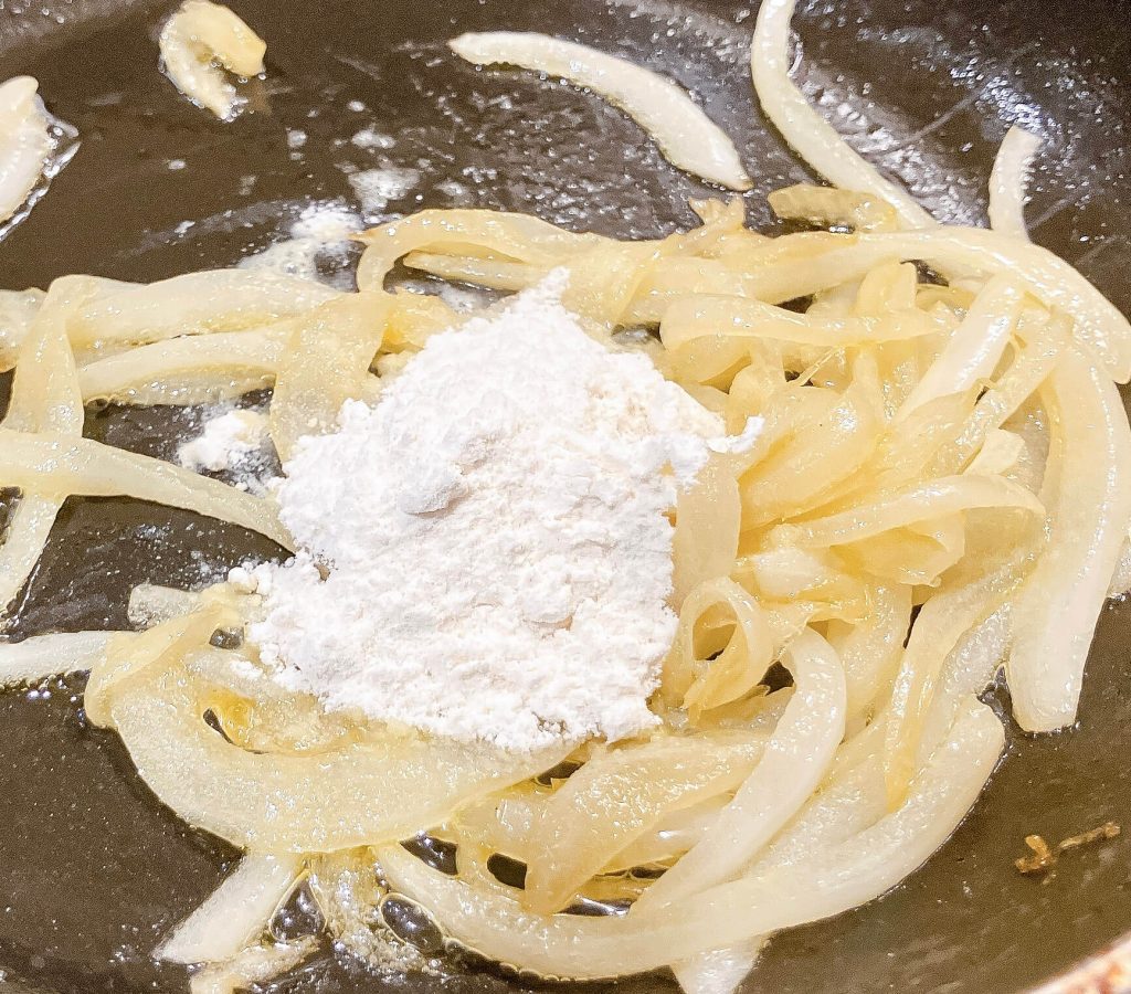 Flour added to softened onions to start gravy roux