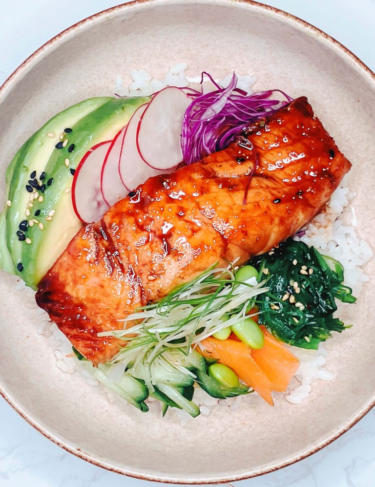 Teriyaki salmon bowl with ginger glaze, avocado, rice, and pickled vegetables