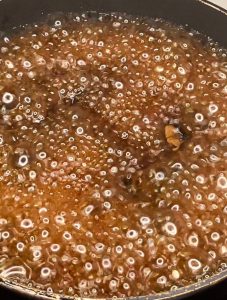 Ginger teriyaki sauce bubbling as it reduces in a pan to thicken and concentrate.