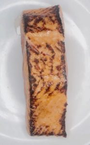 Cooked salmon fillet with a golden brown sear after pan-frying.