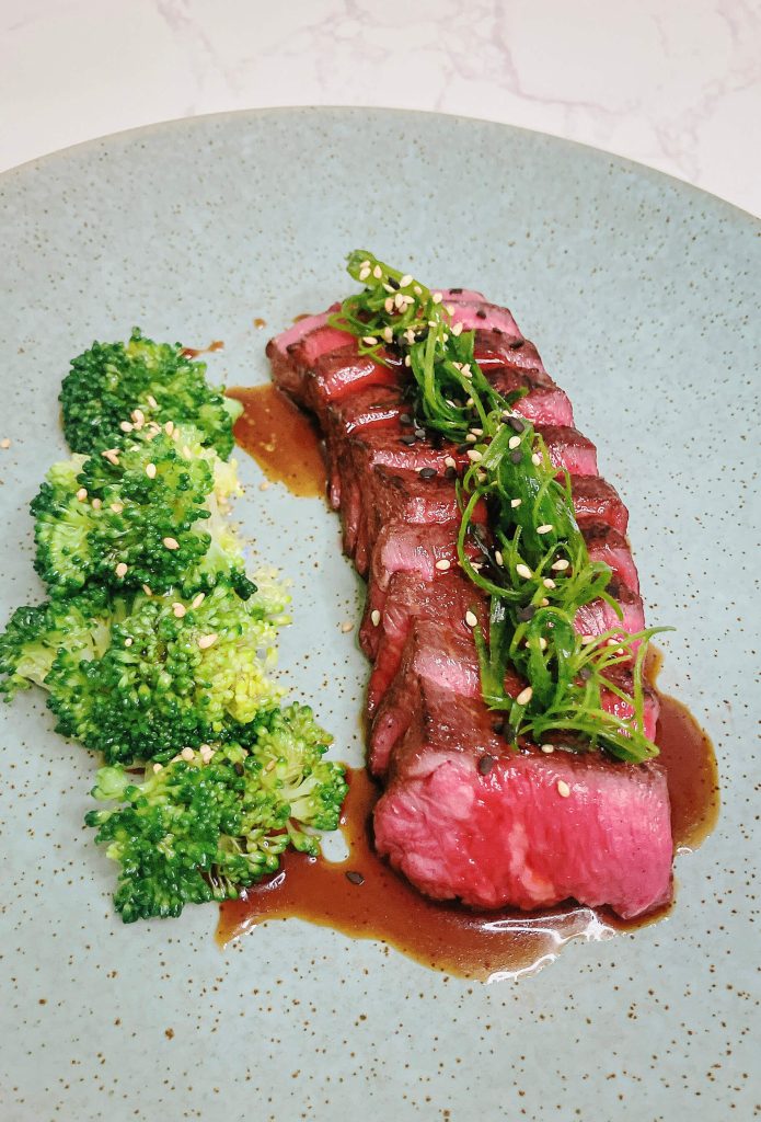 Sliced teriyaki beef glazed with traditional sauce, served with broccoli and scallions