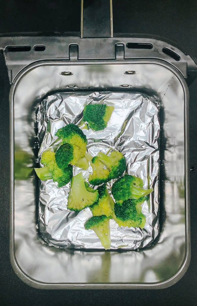 Broccoli florets placed in airfryer basket in a single layer before cooking