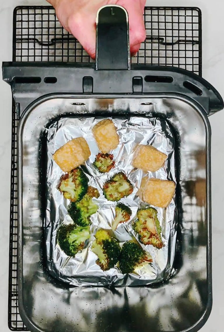 Tofu cubes added to airfryer with broccoli for final crisping before assembling teriyaki broccoli bowl