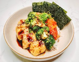 Teriyaki broccoli tofu bowl with rice, kimchi, and sesame