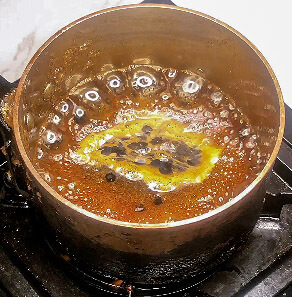 Teriyaki glaze bubbling in saucepan with medium-thick texture at 30% reduction