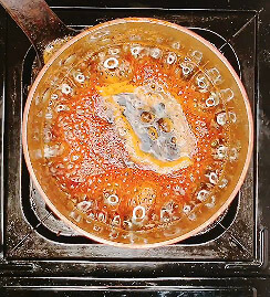 Fully reduced teriyaki sauce bubbling thickly in saucepan – glossy and syrupy