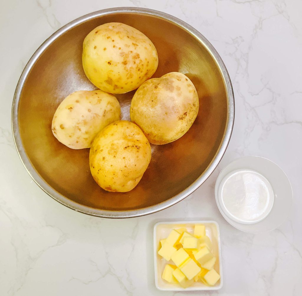 Peeled, diced potatoes with butter and cream — ingredients for classic home-style mashed potatoes.
