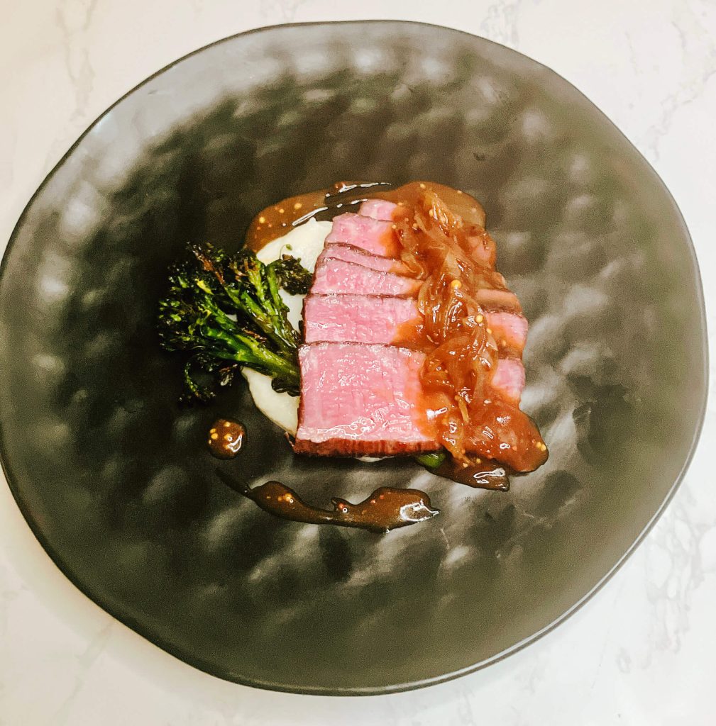Steak served with creamy cauliflower mash and air-fried broccolini, topped with teriyaki onion gravy — a refined, low-carb take on the classic.