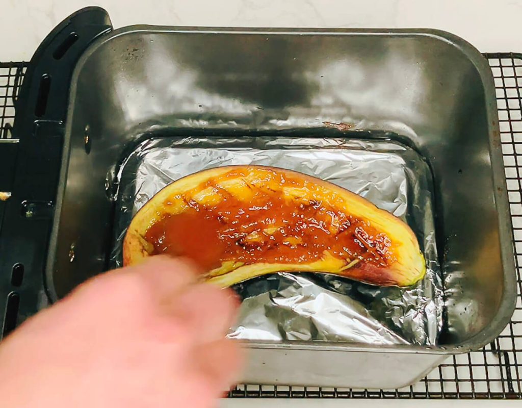 Brushing miso sauce onto eggplant after the first air fry for cauliflower fried rice with miso eggplant.