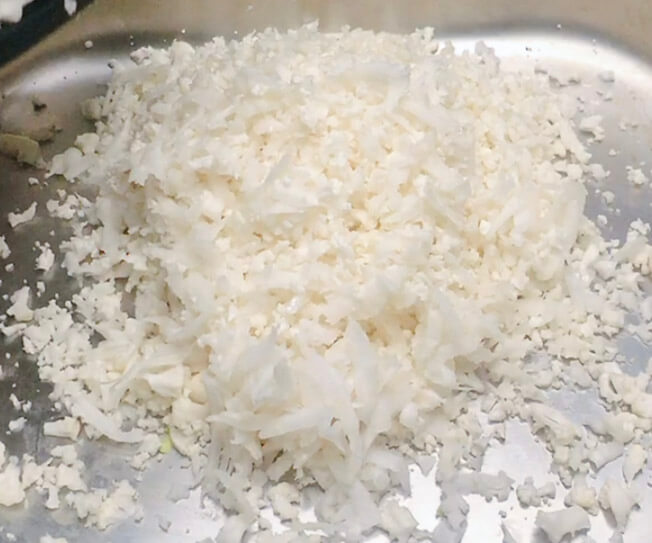 Finished bowl of cauliflower rice grated by hand, showing fluffy rice-sized pieces for keto cauliflower rice.”
