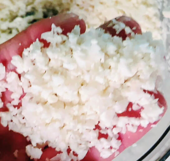 Finished cauliflower rice made in a food processor, showing fine, fluffy rice-sized pieces for keto cauliflower rice