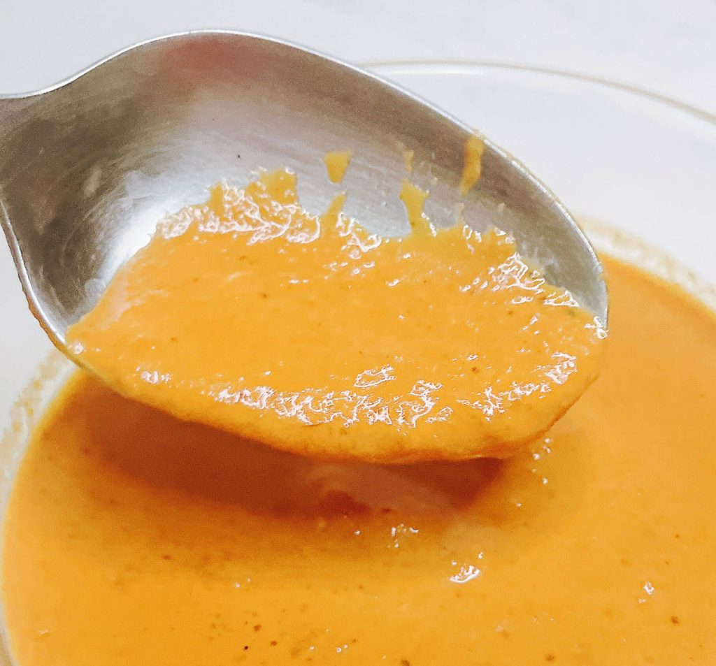 Close-up of keto Japanese curry sauce on a spoon, showing smooth texture.