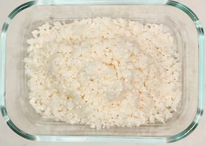 Raw cauliflower rice in a microwave-safe dish before cooking