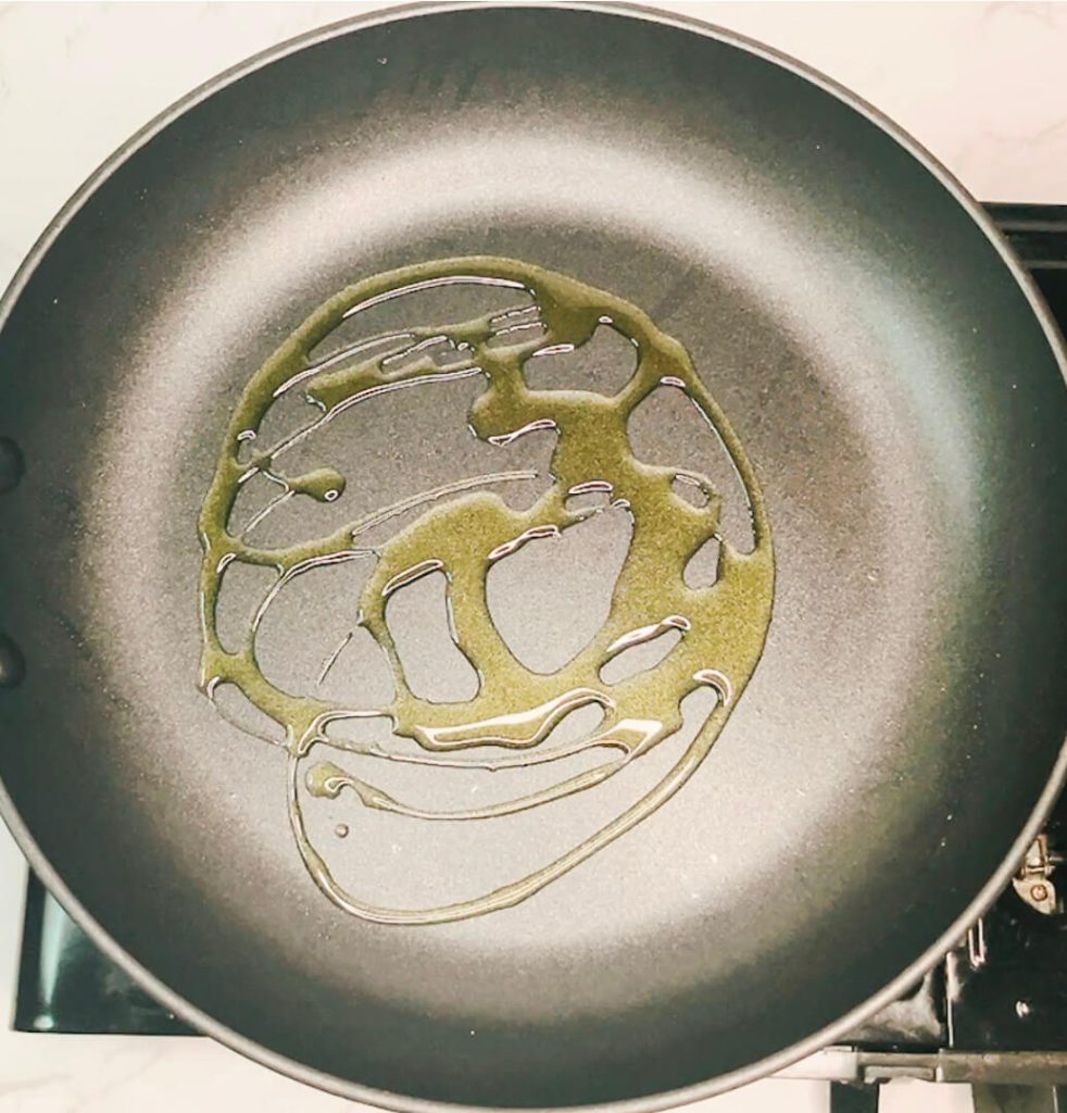 Non-stick skillet with oil heating before adding cauliflower rice for the pan-fried method.”