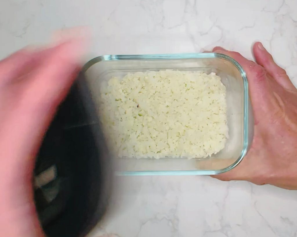 Cooking cauliflower rice in the microwave for lime and cilantro cauliflower rice.
