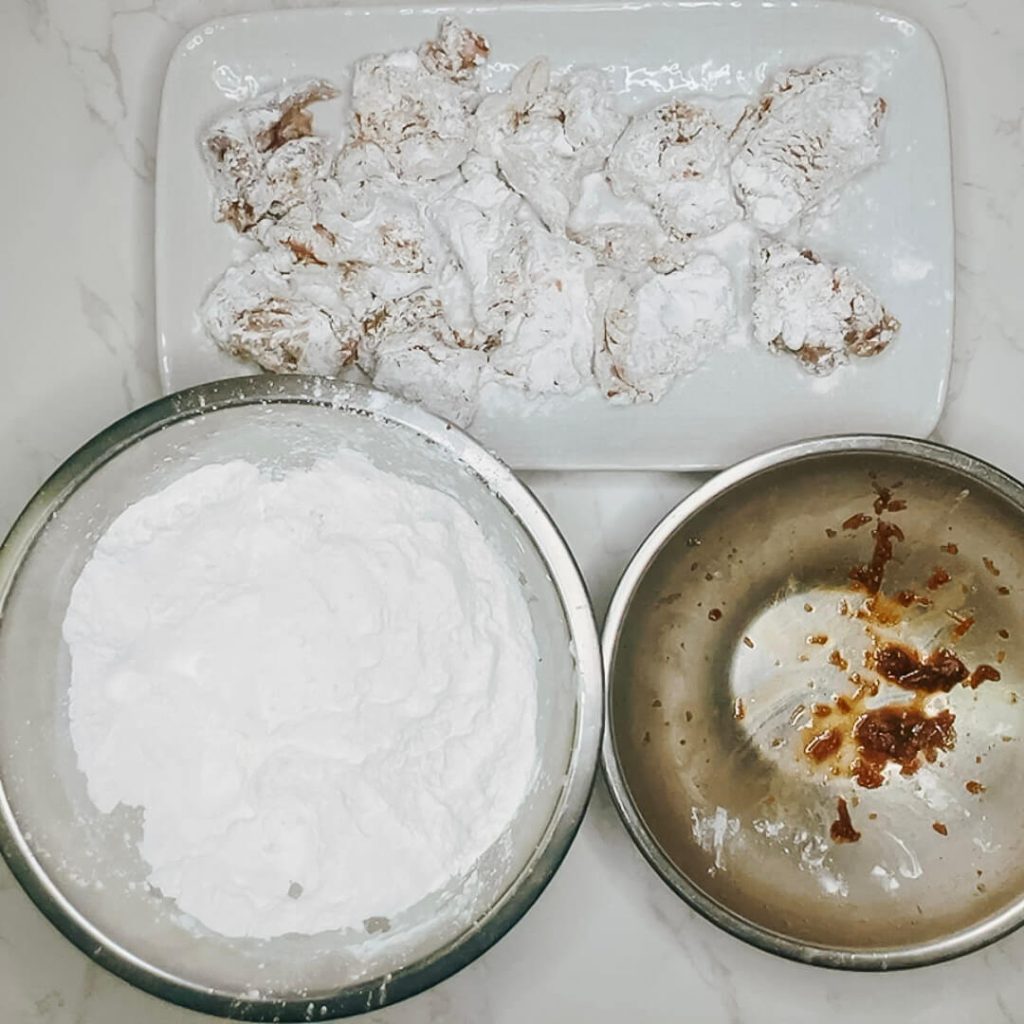 Chicken pieces after the first coating of potato starch for karaage chicken.