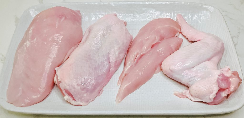 Raw chicken cuts for karaage – breast, thigh, tenderloin, and wing pieces lined up