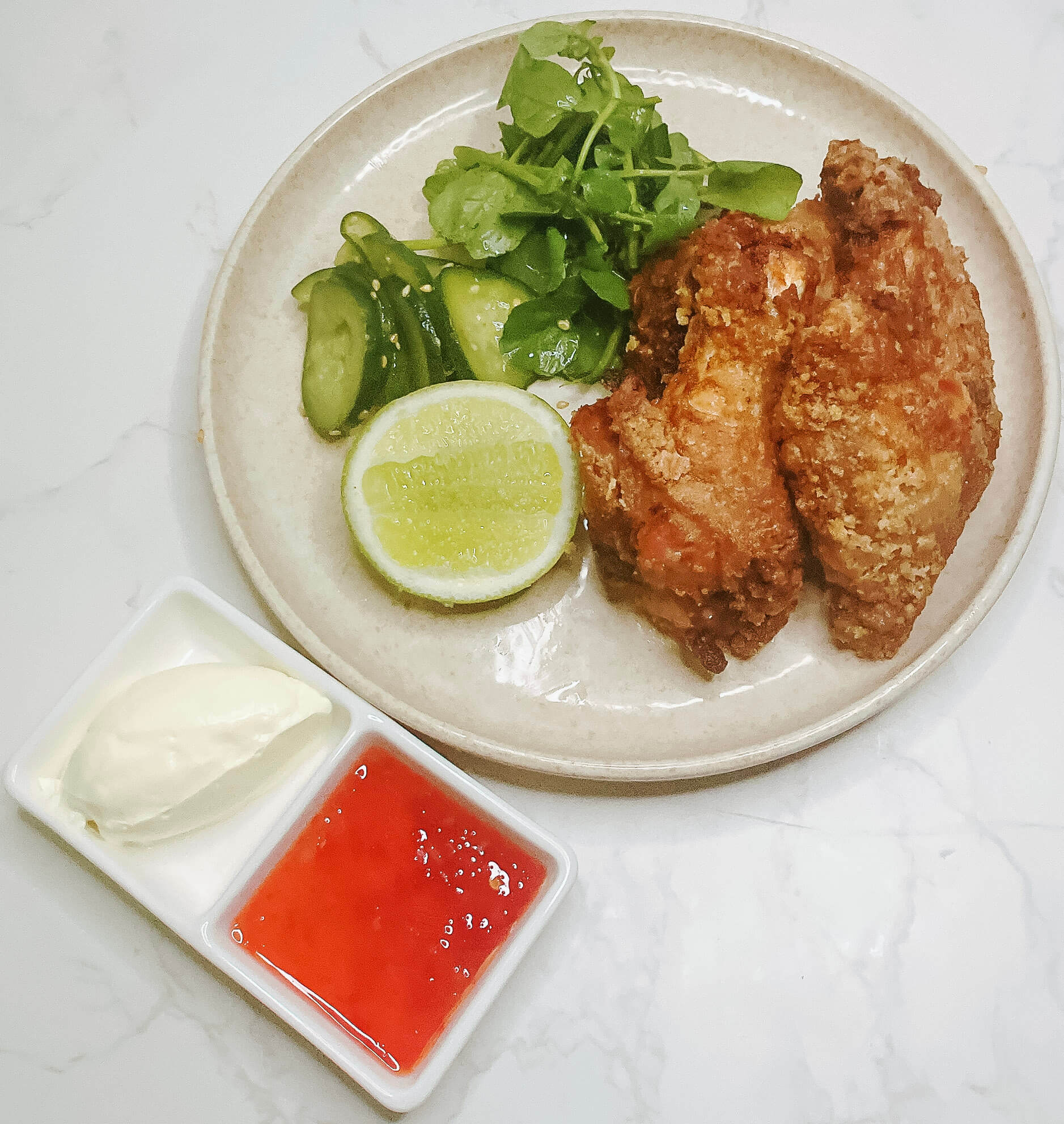 Crispy air fryer karaage chicken with quick cucumber pickles on a plate