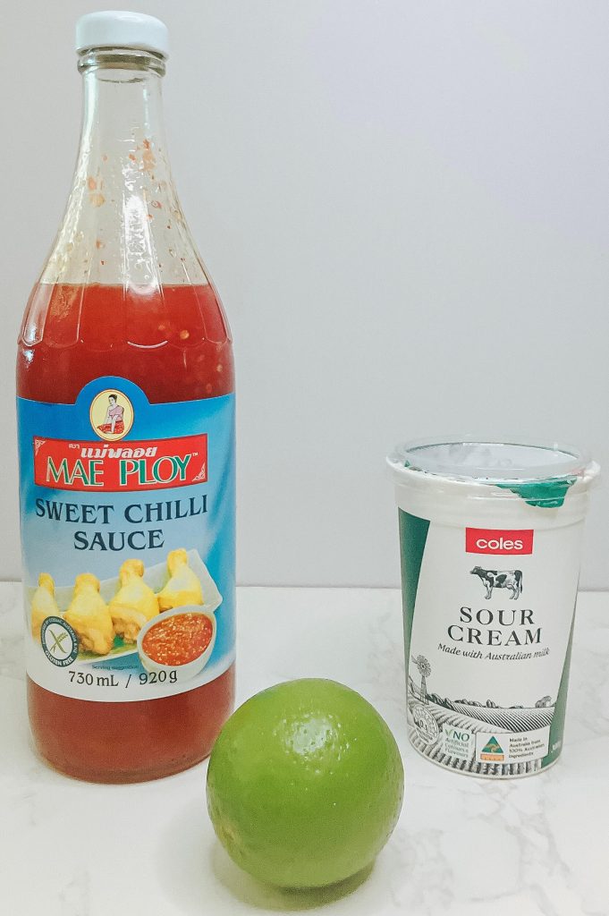 Sweet chili sauce, sour cream, and lime – ingredients to serve as a dipping sauce for karaage chicken