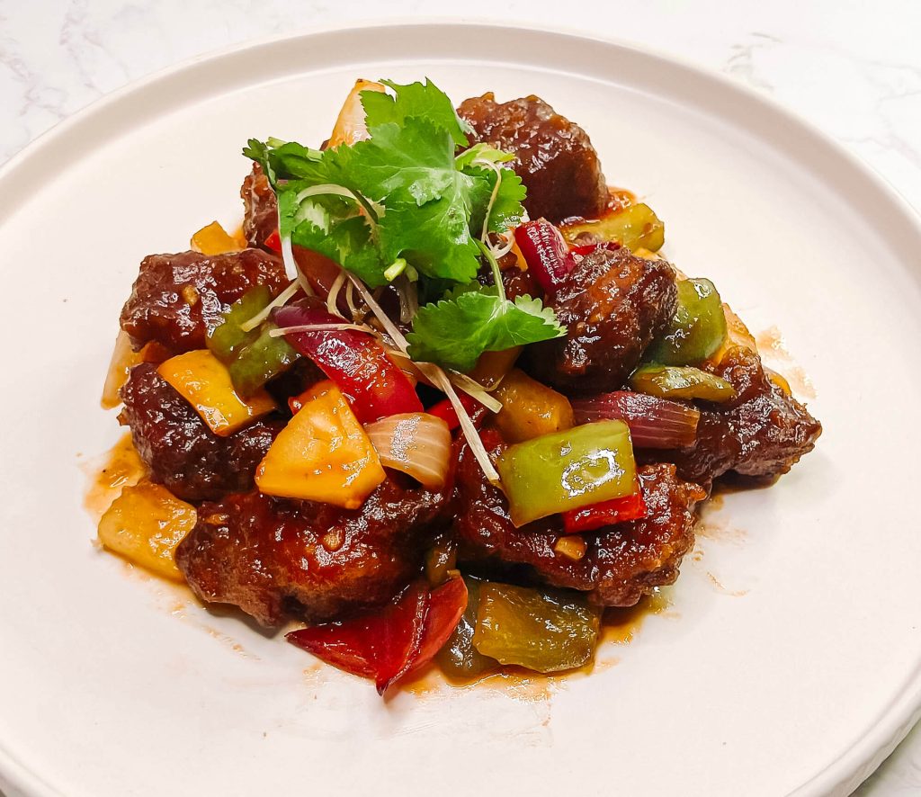 Airfryer sweet and sour pork with ketchup glaze, colorful capsicum, pineapple, and onion.