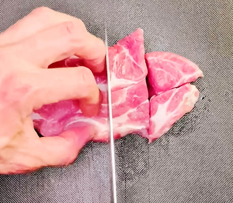 Cutting pork neck into bite-sized cubes for Japanese-style sweet and sour pork (Subuta).