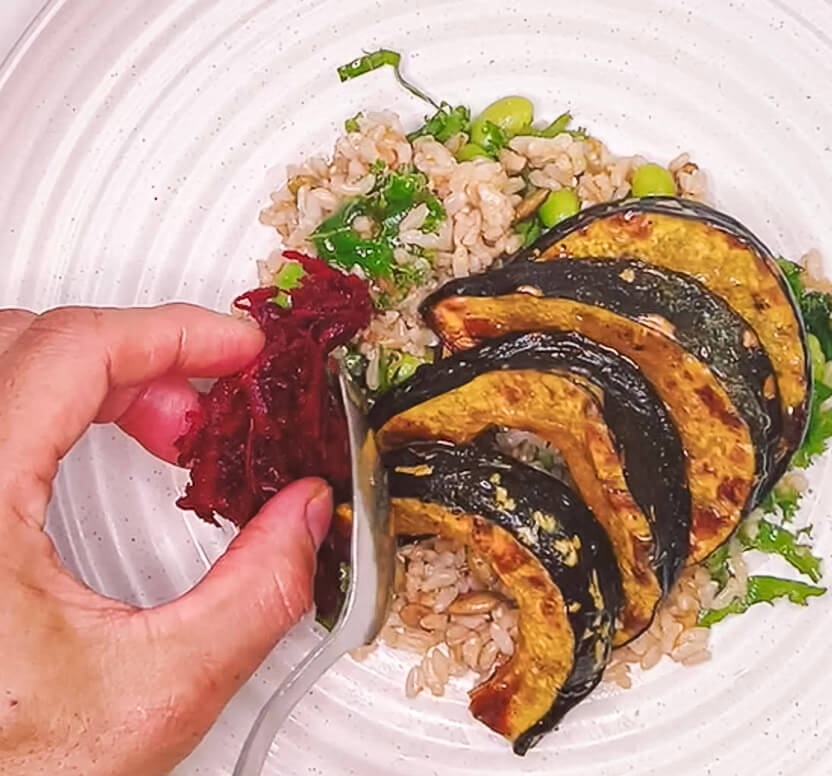 adding grated beetroot to brown rice salad