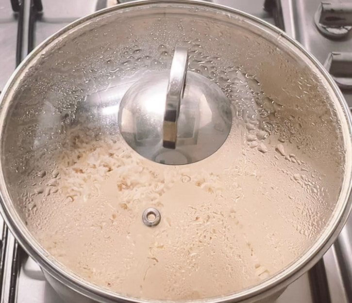Brown rice resting in covered pot after cooking on stovetop