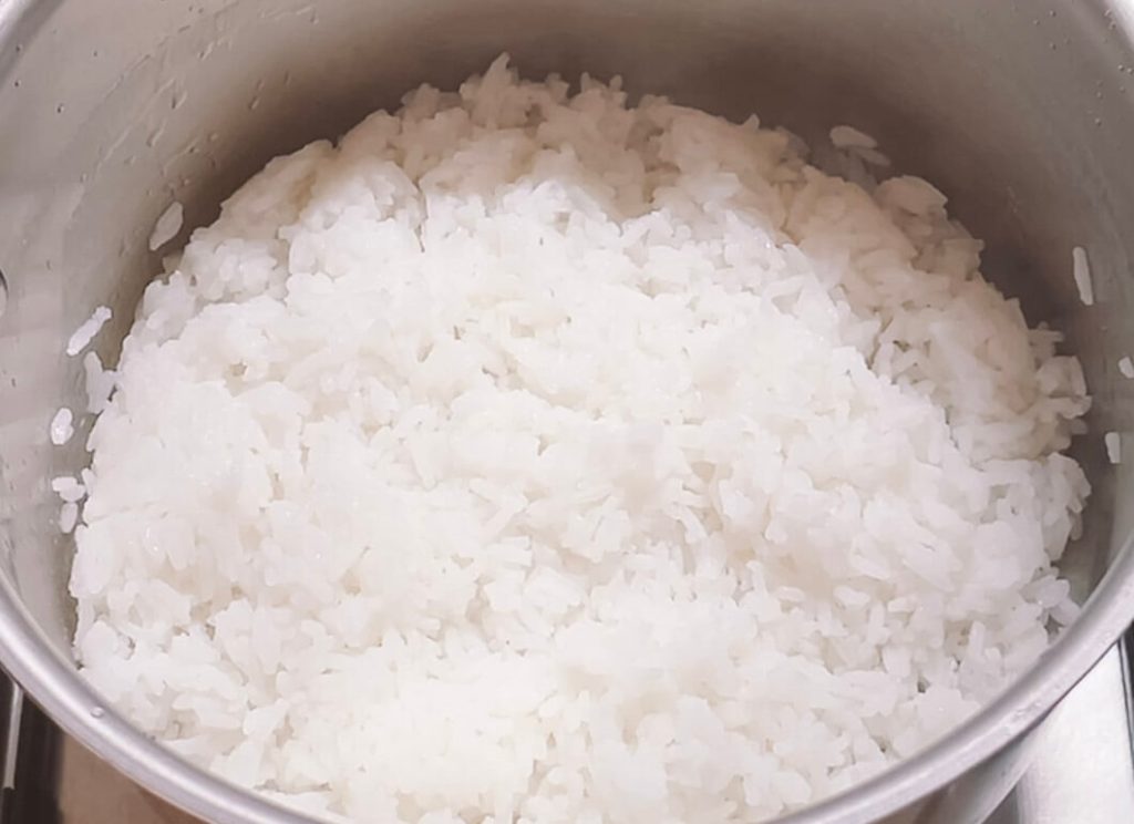 Boiled rice resting in a warm pot after draining