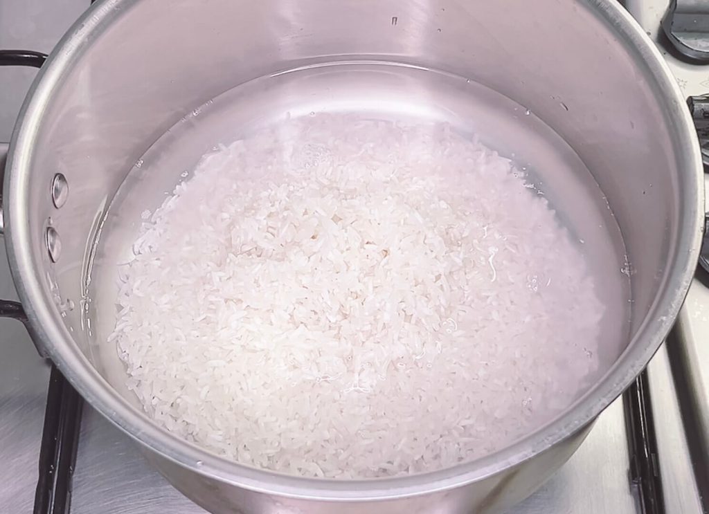 Rice and water in pot before cooking using the absorption method