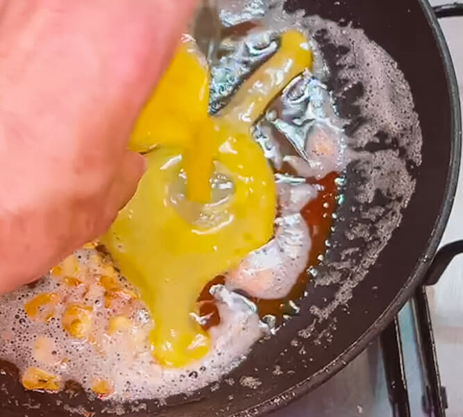 Adding egg to pan with garlic butter for fried rice