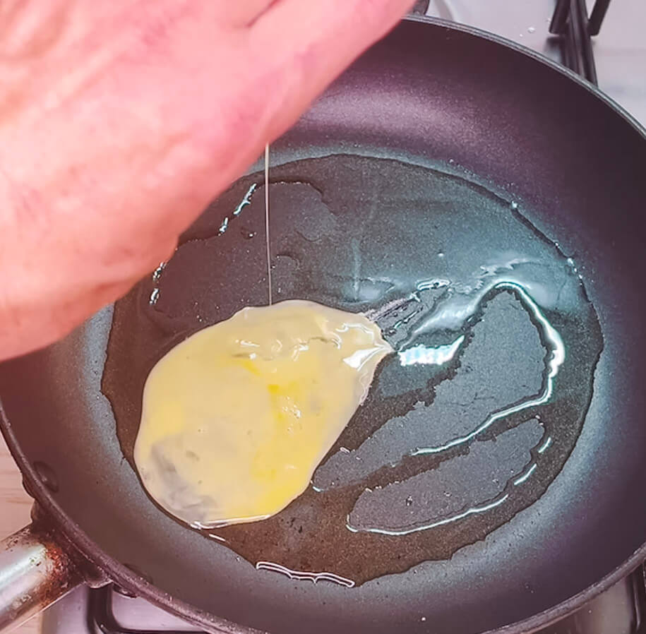 Adding egg to hot pan with oil for Japanese fried rice
