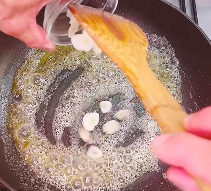 Adding sliced garlic to melted butter for garlic butter fried rice