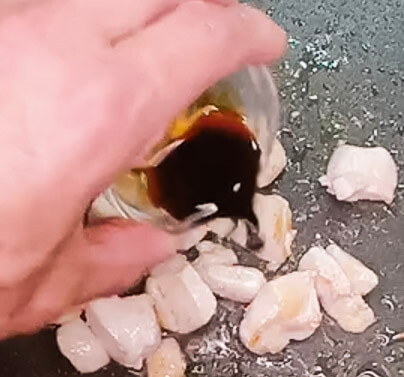 Adding soy sauce to chicken while cooking for fried rice