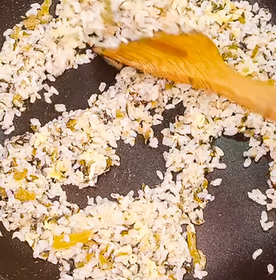 Breaking up rice gently in takana fried rice to keep grains separate