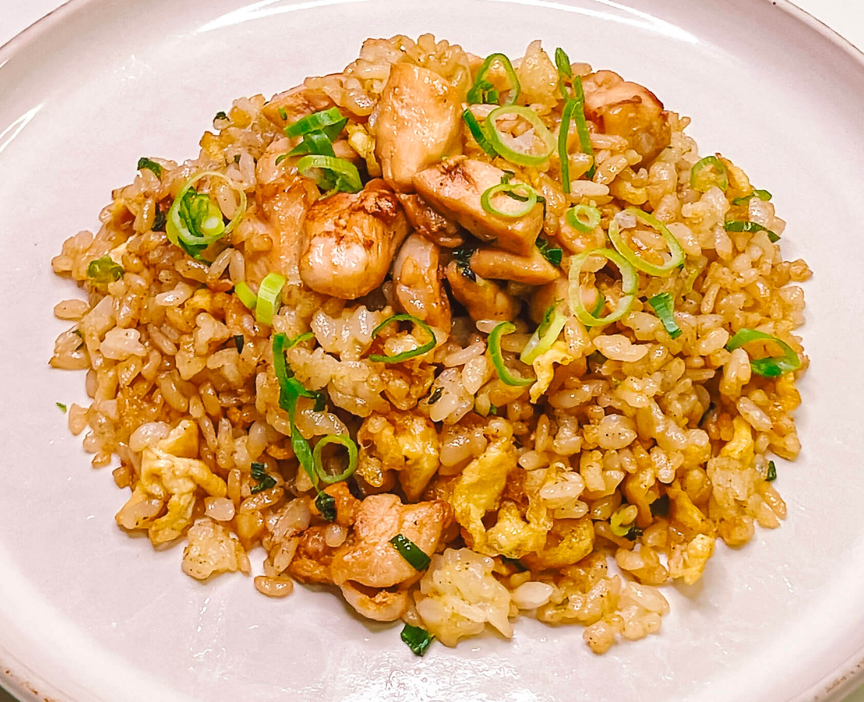 Chicken Japanese fried rice with egg-coated rice, soy-seasoned chicken and spring onion
