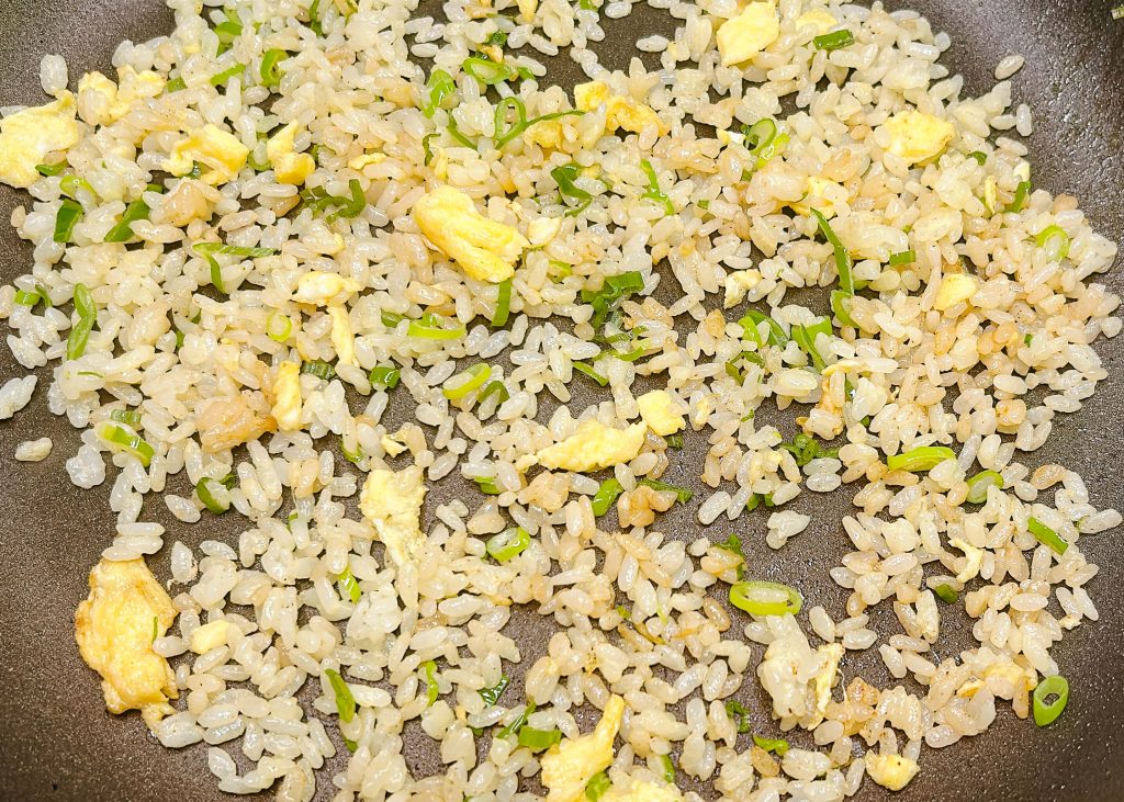 Egg-mixed fried rice in pan showing light and separated grains