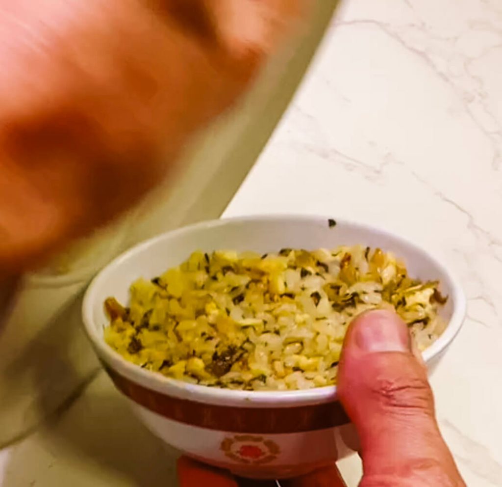 Covering a bowl of fried rice with a plate before flipping