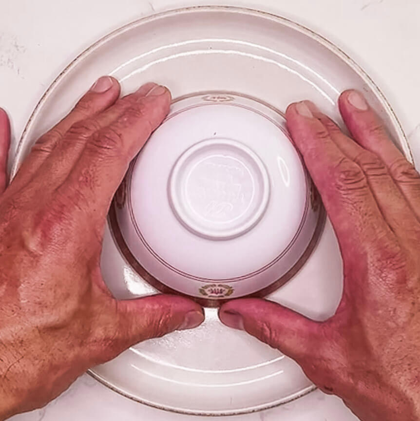 Lifting the bowl to release moulded fried rice onto a plate