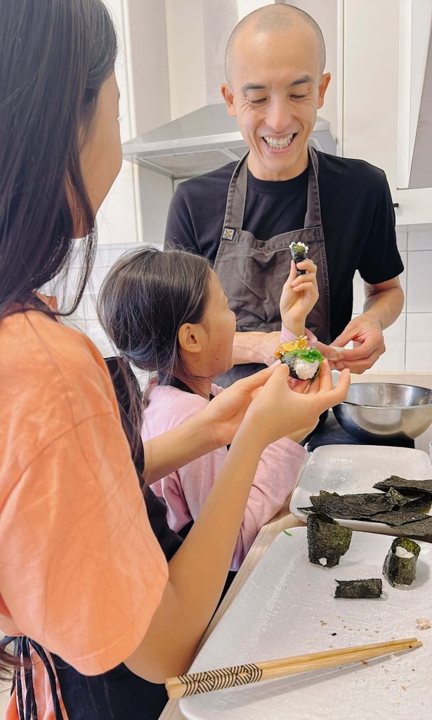 Kenji cooking with his daughters in the kitchen