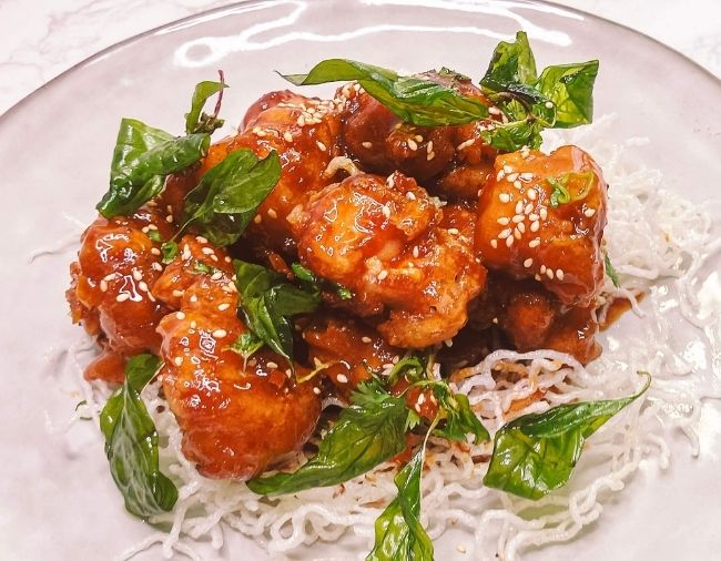 Crispy honey soy chicken with sesame seeds and spring onion
